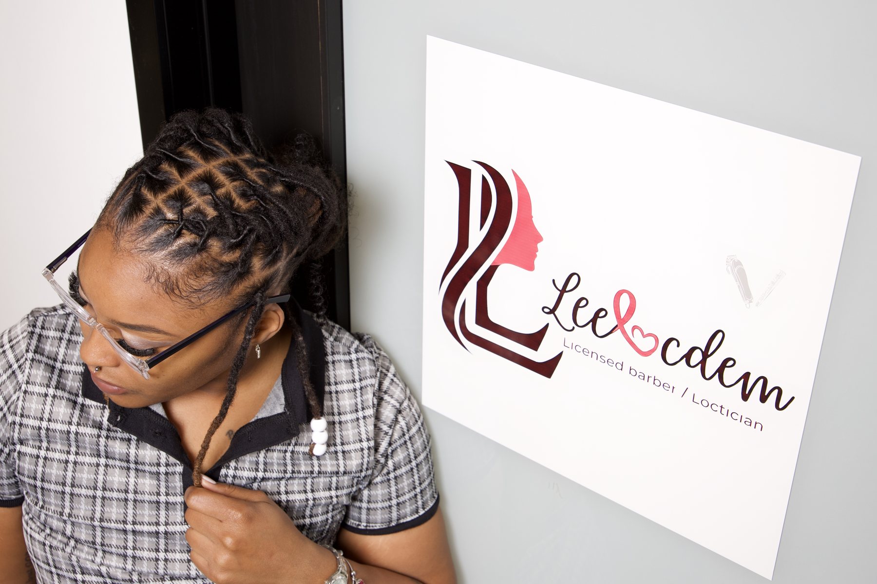 Detail of sectioned locs beside the LEELOCDEM logo sign